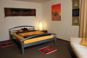 a bedroom with a bed with a lamp and a couch at BnB im Grossacker in Münchwilen