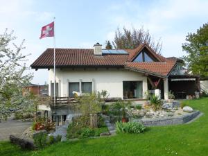 a house with a flag in the yard at BnB im Grossacker in Münchwilen