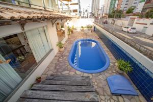 a blue swimming pool on the side of a building at Casa de Maria Suítes in Recife