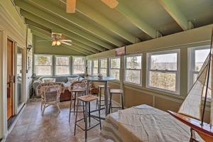 Cette chambre comprend une table, des chaises et des fenêtres. dans l'établissement Auburn Vacation Rental Home Near Owasco Lake!, à Auburn