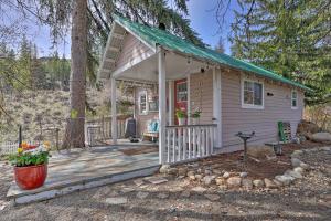 Historic Twisp Cottage - Mountain and River View! في Twisp: منزل صغير مع شرفة وسطح