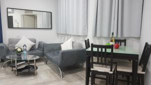 een woonkamer met een bank en een tafel bij By The Sea Vacation Suite in Ashkelon
