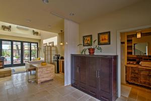 a living room with a wooden cabinet and a table at Cozy Casita with Mtn View and Pool and Hot Tub Access in Carefree