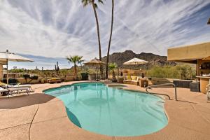 a swimming pool in a resort with palm trees at Cozy Casita with Mtn View and Pool and Hot Tub Access in Carefree