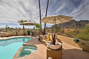 a swimming pool with an umbrella and chairs at Cozy Casita with Mtn View and Pool and Hot Tub Access in Carefree