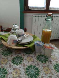 uma mesa com um prato e uma garrafa de sumo de laranja em Il Nido B&B em Villa dʼAllegno