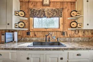a kitchen with a sink and a window at Baldwin Cabin with Private Beach on Little Lake! in Baldwin