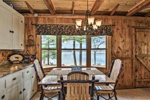 a dining room with a table and chairs and a window at Baldwin Cabin with Private Beach on Little Lake! in Baldwin