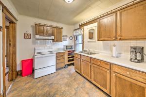 a kitchen with wooden cabinets and a white appliance at Charming Urbana Home Near Downtown! in Urbana
