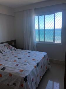 um quarto com uma cama e vista para o oceano em Solaris Residencial Clube 1601 de Frente Para o Mar em Ilhéus