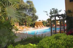 una piscina con sedie e un gazebo accanto a una piscina di Residence Helios a Cargèse