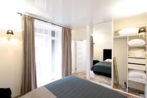 1 dormitorio con cama y espejo en Lviv center VIP new building, en Leópolis