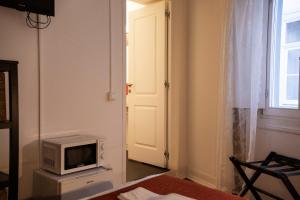 Cette chambre dispose d'une télévision et d'une porte avec fenêtre. dans l'établissement Burgos Guest House, à Évora