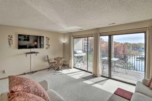 a living room with a couch and a balcony at Lake Ozark Condo with Pool and Fishing Docks! in Lake Ozark
