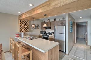 a kitchen with a stainless steel refrigerator and wooden cabinets at Lake Ozark Condo with Pool and Fishing Docks! in Lake Ozark