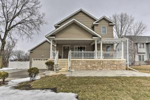 a house with a porch and a white fence at Eagan Home with Porch - 5 Mi to Mall of America! in Eagan