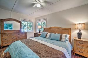 une chambre avec un lit et un ventilateur de plafond dans l'établissement Riverfront Cottage in Redwoods with Decks and Beach!, à Ben Lomond