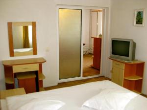 - une chambre avec un lit, une télévision et un miroir dans l'établissement HOSTEL CONDOR, à Rânca