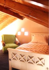 1 dormitorio con 1 cama y 1 silla verde en Estación Aeropuerto Ezeiza en Lomas de Zamora