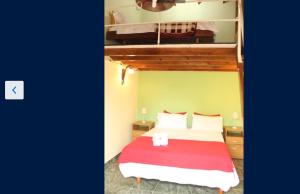 1 dormitorio con litera y manta roja en Estación Aeropuerto Ezeiza en Lomas de Zamora