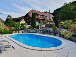 a pool in a yard with chairs and a house at Hansenchristenhof in Gutach