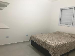 1 dormitorio con cama y ventana en Apartamento Praia de Boraceia - Litoral Norte SP en Boracéia