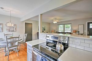 a kitchen with a stove and a dining room at Modern Excelsior Springs Home with Deck and 3 Acres! in Excelsior Springs