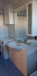 a bathroom with a sink and a washing machine at Residence Ca' D'Oro in Cavallino-Treporti +31 photos