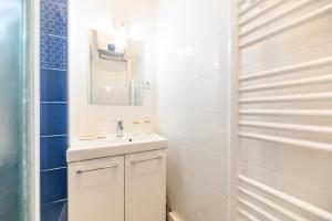 a white bathroom with a sink and a mirror at Daumier - New 2 Bdrs Flat near la Seine in Paris +19 photos