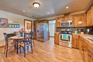eine Küche mit Holzschränken und einem Tisch mit Stühlen in der Unterkunft McAlester Cottage with 30 Private Acres and Ponds! in McAlester
