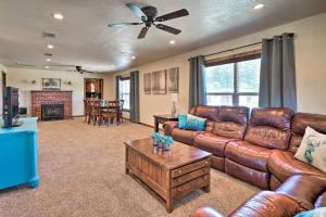 ein Wohnzimmer mit einem braunen Ledersofa und einem Tisch in der Unterkunft McAlester Cottage with 30 Private Acres and Ponds! in McAlester