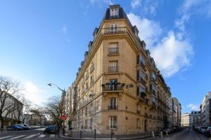 a tall yellow building on the corner of a street at Daumier - New 2 Bdrs Flat near la Seine in Paris