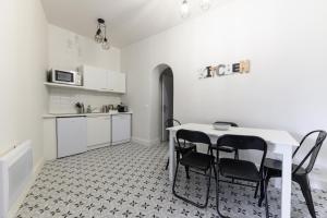 a kitchen with a table and chairs in a room at Daumier - New 2 Bdrs Flat near la Seine in Paris