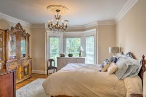 a bedroom with a large bed and a chandelier at Historic Cedar Hill Mansion on Large Farm with Pool! in Pleasant View +32 photos