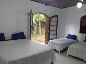 2 letti in una camera con finestra e scala di Suites próximo ao rio Jaguareguava em Bertioga a Bertioga