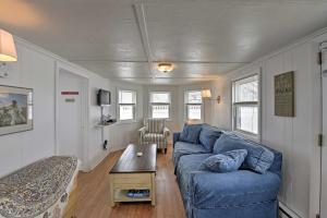 uma sala de estar com um sofá azul e uma mesa em Peaceful Cottage with Grill - Steps to Matunuck Beach em South Kingstown