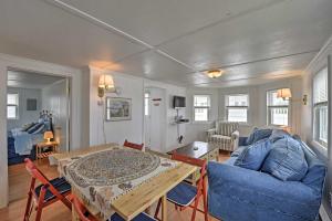 uma sala de estar com um sofá azul e uma mesa em Peaceful Cottage with Grill - Steps to Matunuck Beach em South Kingstown