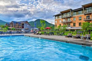 einen Pool in einem Resort mit Stühlen und Tischen in der Unterkunft Ski-In Resort Family Condo with Deck at Jay Peak! in Jay