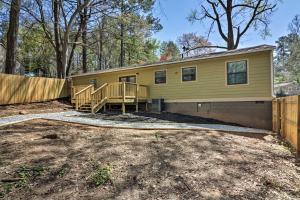 a yellow house with a wooden fence at Comfortable Ranch Home - 5 Mi to Downtown Atlanta! in Atlanta