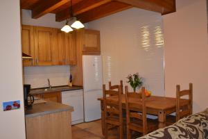 eine Küche mit einem Tisch und eine Küche mit einem Kühlschrank in der Unterkunft Casa rural La Senderilla in Avila