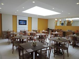a restaurant with wooden tables and chairs in a room at Hotel Belas Artes in Rio de Janeiro