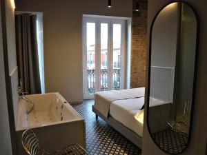 a bathroom with a bed and a tub and a mirror at YOU & CO. Quart Boutique in Valencia