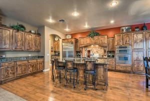 a large kitchen with wooden cabinets and bar stools at Luxe Gilbert Home with Heated Pool and Putting Green! in Gilbert
