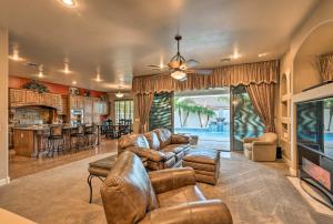 a living room with leather furniture and a fireplace at Luxe Gilbert Home with Heated Pool and Putting Green! in Gilbert