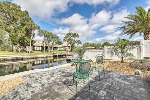a patio with two chairs and a table next to a canal at Canal-Front Home with Boat Dock in Crystal River in Crystal River