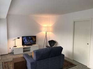 a living room with a blue couch and a television at Apartamento Padrón Centro P1 by URent in Padrón +11 photos
