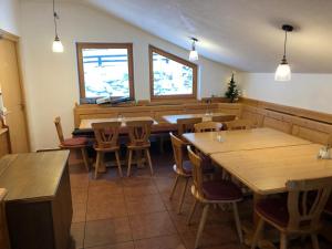 um restaurante com mesas e cadeiras de madeira e janelas em Chalet Elfie em Sankt Anton am Arlberg