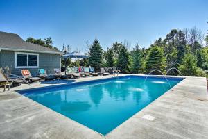 a swimming pool with chairs and a house at 7-Acre Coastal Michigan Home with Hot Tub and Sauna! in Ludington
