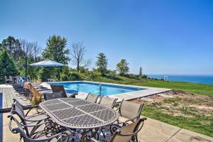 a table and chairs next to a swimming pool at 7-Acre Coastal Michigan Home with Hot Tub and Sauna! in Ludington