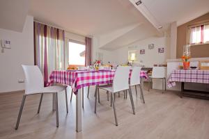 ein Esszimmer mit einem Tisch und weißen Stühlen in der Unterkunft Il Sogno in Avio